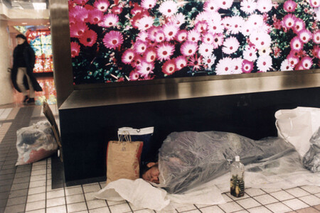 THE SUBWAY: GINZA STATION. HOMELESS SLEEPING UNDER A BENCH WITH A PANEL WITH A PICTURE OF FLOWERS.
LA METROPOLITANA: GINZA. SENZA CASA DORME SOTTO UNA PANCHINA CON UN PANNELLO DI FIORI.